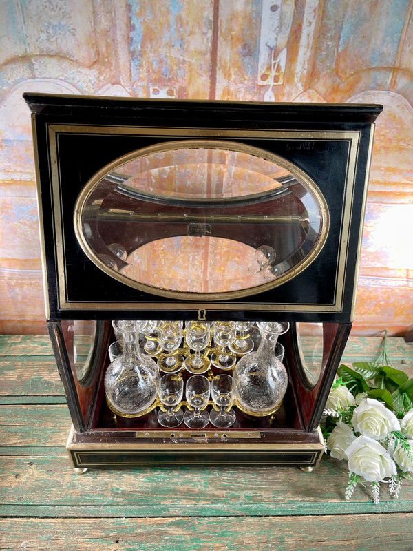 Napoleon III liqueur cellar in black wood, with brass fillets and chased glass portholes