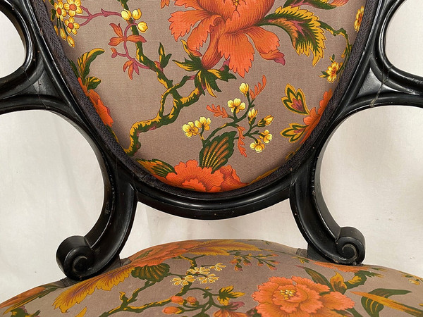 Pair of Napoleon III armchairs, in blackened wood, upholstered in floral fabric.
