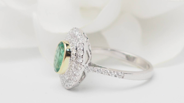 Bague entourage en or bicolore, émeraude ovale et diamants