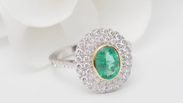 Bague entourage en or bicolore, émeraude ovale et diamants