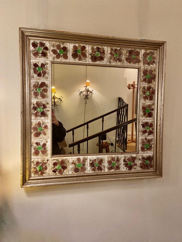 Large square ceramic mirror with floral decoration.