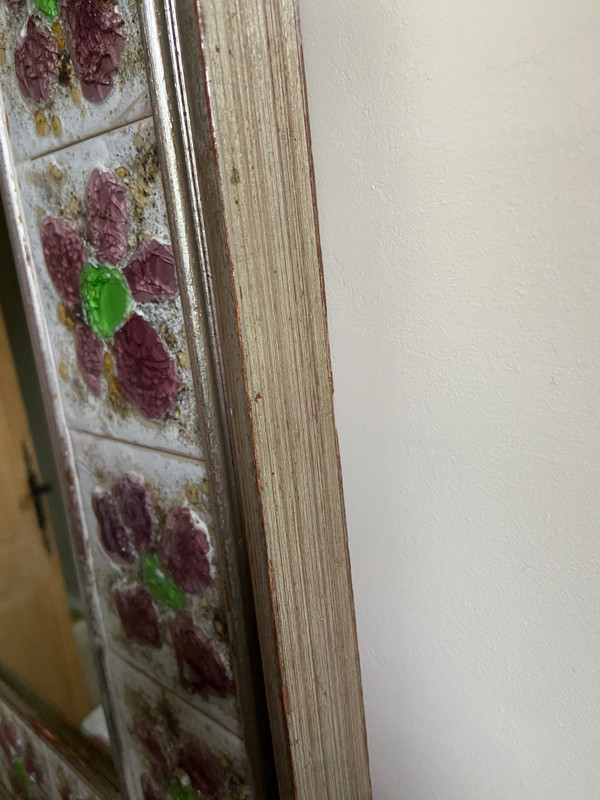 Large square ceramic mirror with floral decoration.