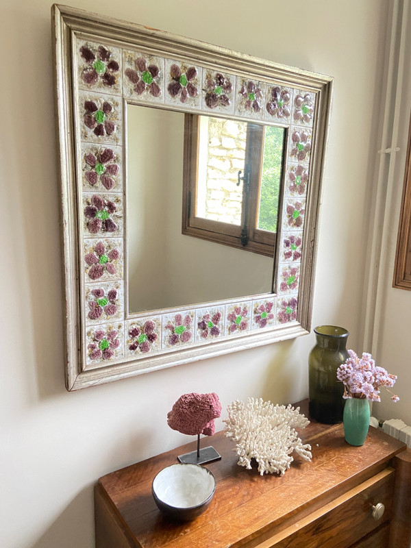 Large square ceramic mirror with floral decoration.