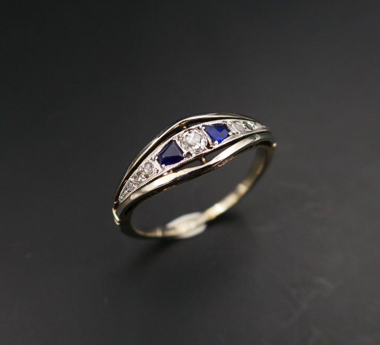 Anello giarrettiera con diamanti e zaffiri calibrati, oro e platino.