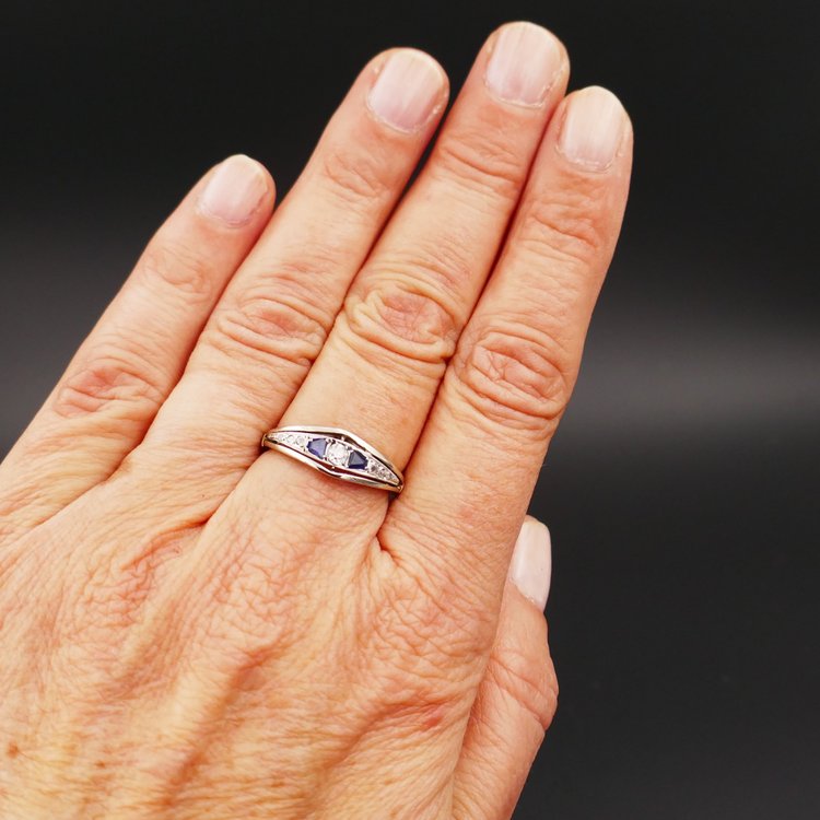 Anello giarrettiera con diamanti e zaffiri calibrati, oro e platino.