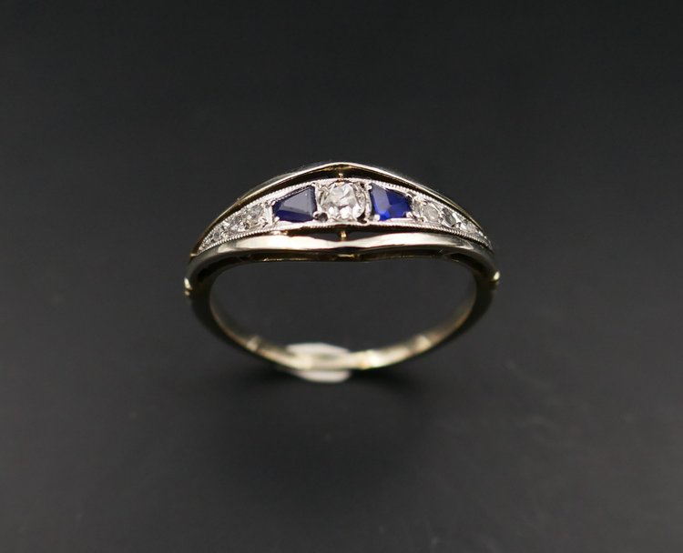 Anello giarrettiera con diamanti e zaffiri calibrati, oro e platino.