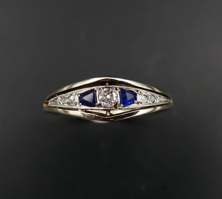 Anello giarrettiera con diamanti e zaffiri calibrati, oro e platino.