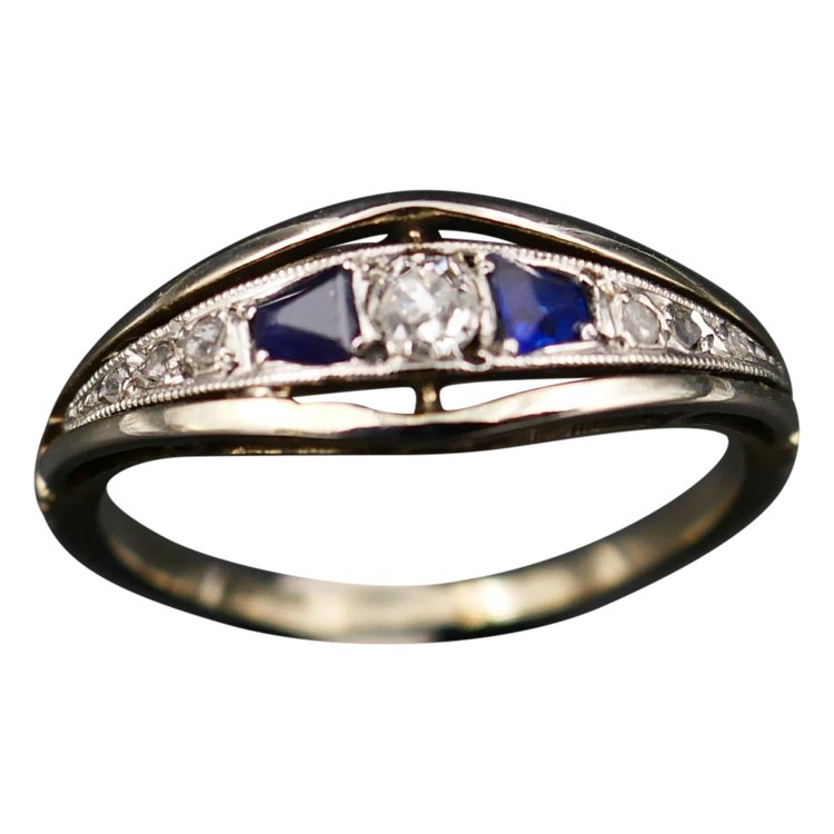 Anello giarrettiera con diamanti e zaffiri calibrati, oro e platino.
