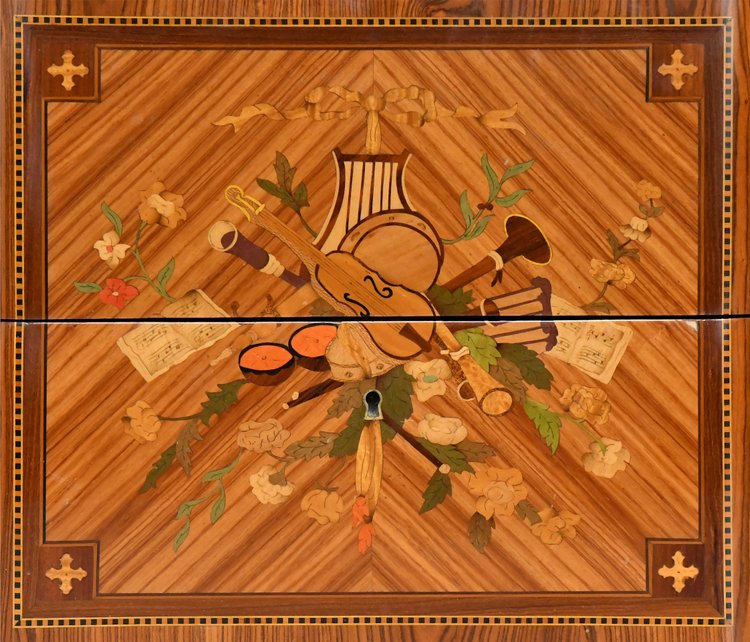 Commode de style Transition en marqueterie à décor de trophée aux instruments de musique 