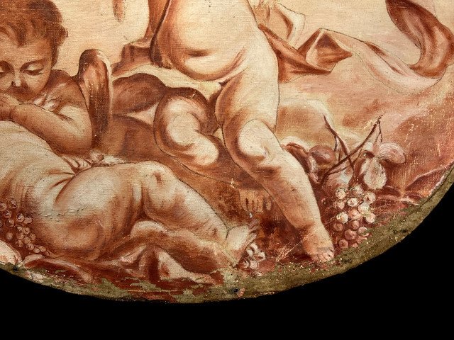 OIL ON OVAL WOOD PANELING DECORATED WITH CHERUBS CARRYING A FRUIT BOWL