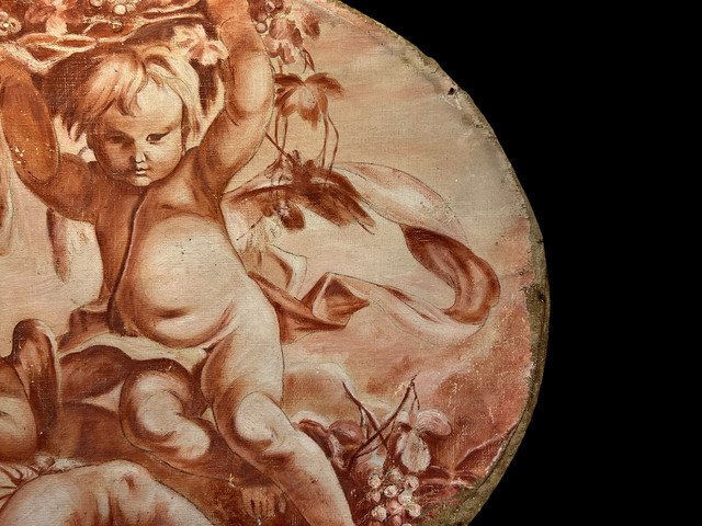 OIL ON OVAL WOOD PANELING DECORATED WITH CHERUBS CARRYING A FRUIT BOWL