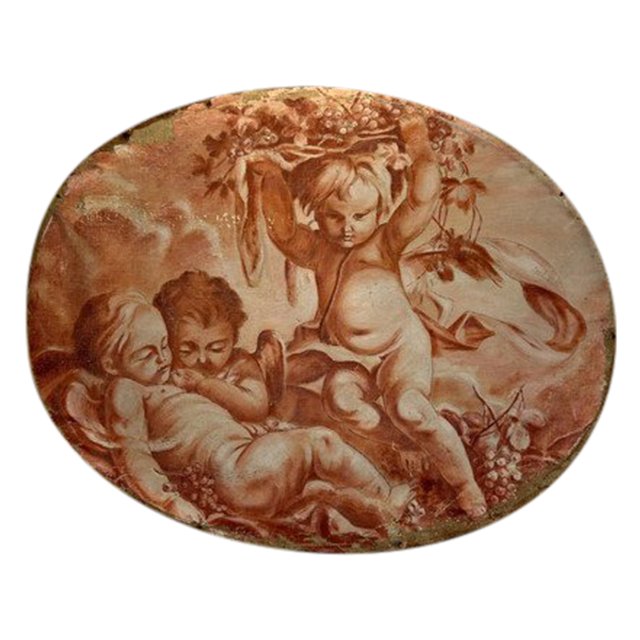 OIL ON OVAL WOOD PANELING DECORATED WITH CHERUBS CARRYING A FRUIT BOWL