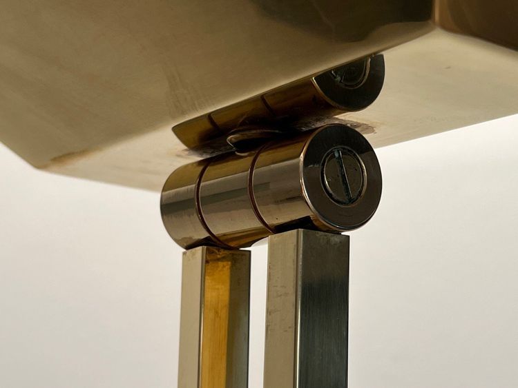 Lampada da terra in ottone con riflettore regolabile su base in travertino e ottone.
