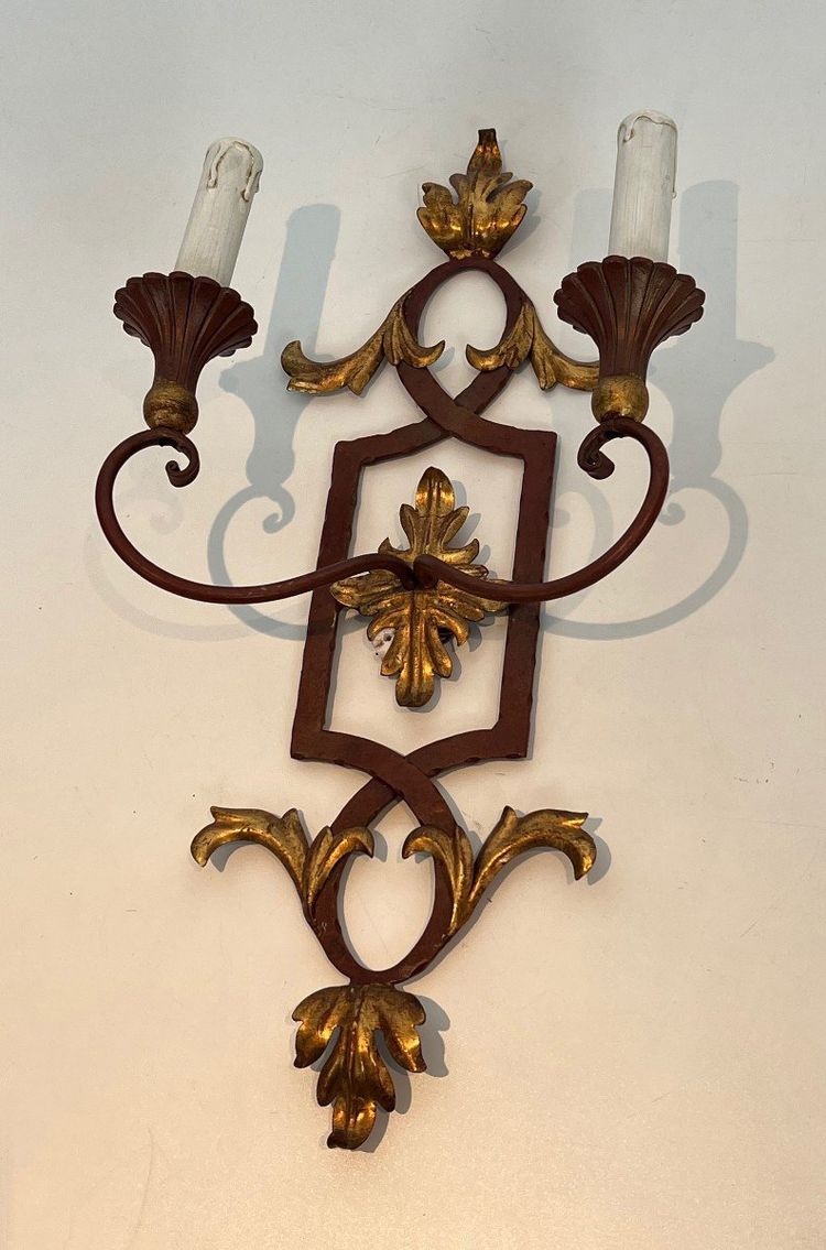 Coppia di applique in ferro battuto e legno rosso antico con foglie d'acanto dorate.