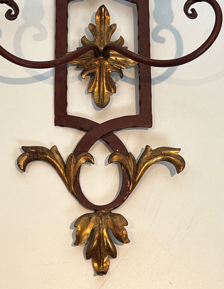 Coppia di applique in ferro battuto e legno rosso antico con foglie d'acanto dorate.