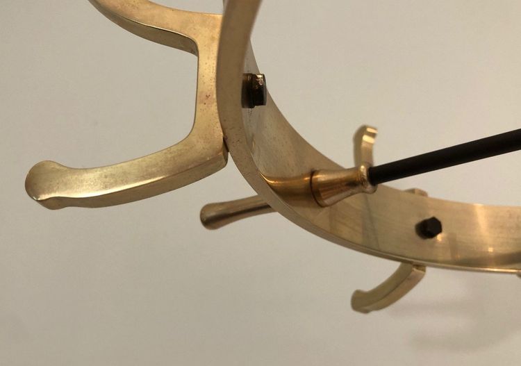 Appendiabiti in metallo laccato nero e ottone, opera francese di Jacques Adnet. Intorno al 1950
