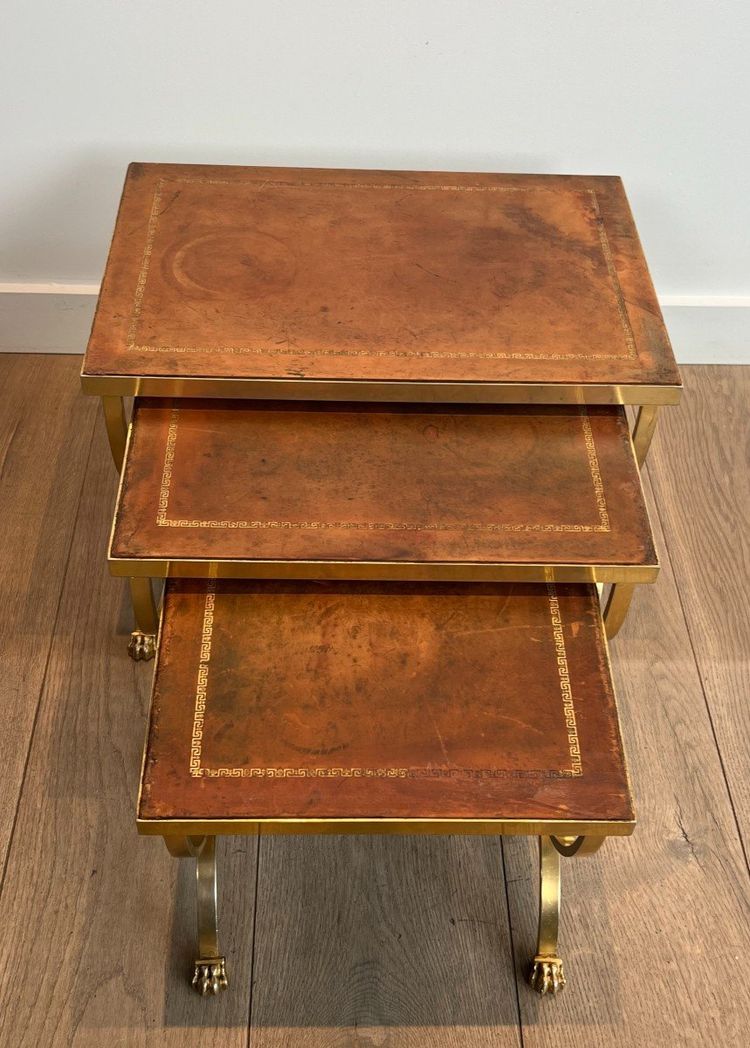 Suite di tavoli giganti in metallo dorato con piedini griffati e piastre in pelle. Opera francese