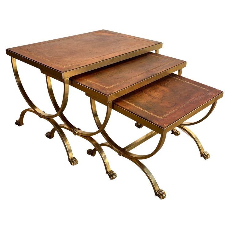 Suite di tavoli giganti in metallo dorato con piedini griffati e piastre in pelle. Opera francese