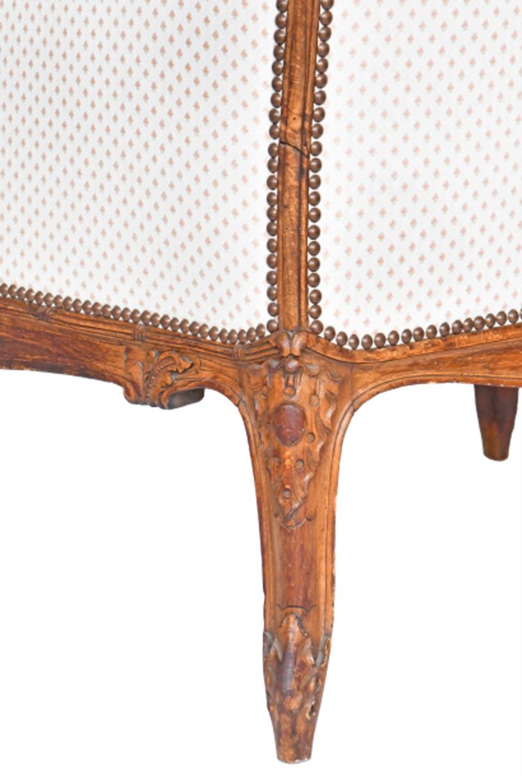 Fauteuil bergère à oreilles de style Louis XV en bois richement sculpté