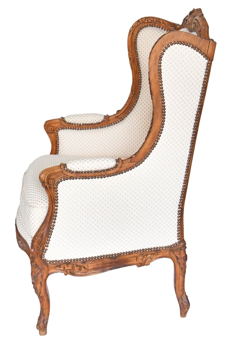 Fauteuil bergère à oreilles de style Louis XV en bois richement sculpté