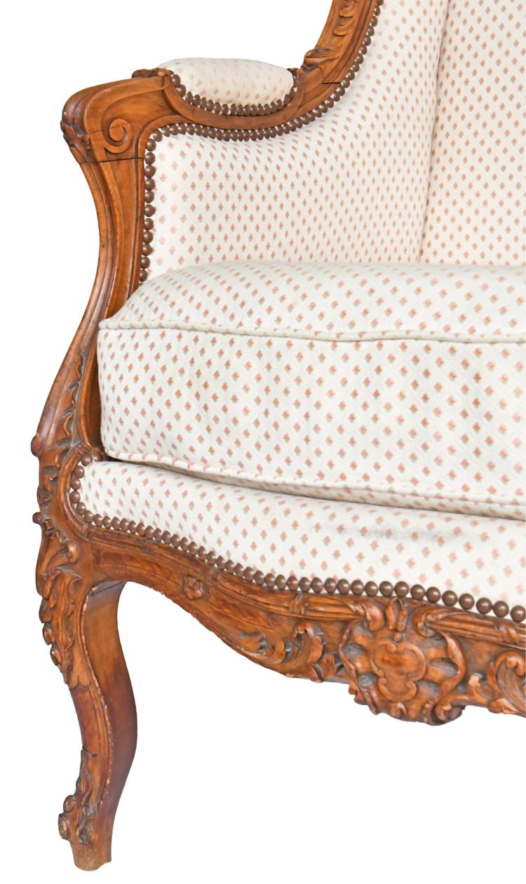 Fauteuil bergère à oreilles de style Louis XV en bois richement sculpté