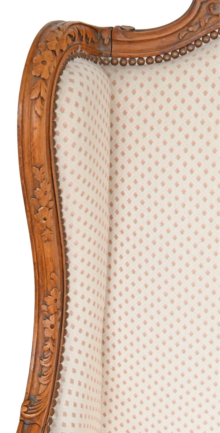 Fauteuil bergère à oreilles de style Louis XV en bois richement sculpté