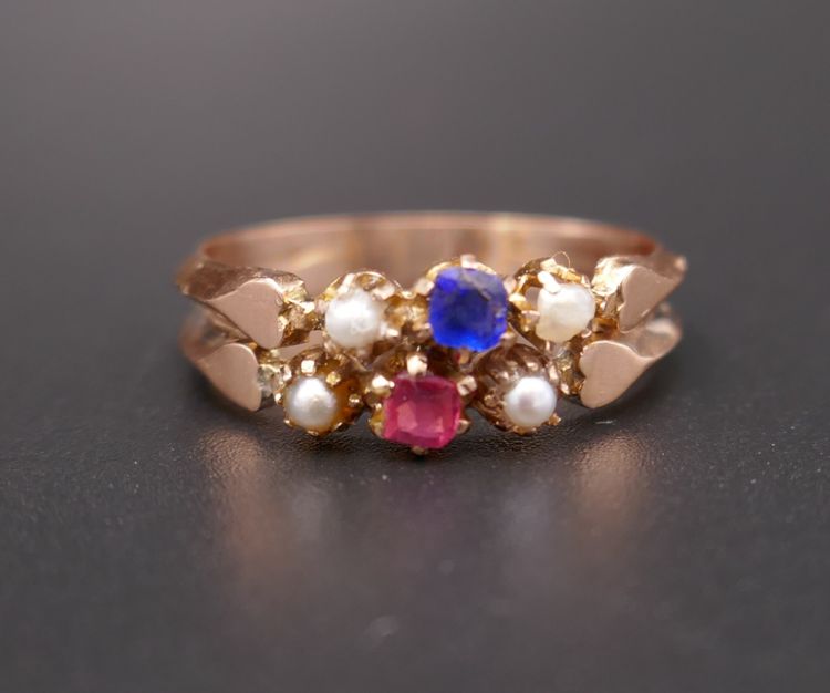 Antiker Ring mit Pferdekopf-Stempel, roten und blauen Steinen und Perlen.
