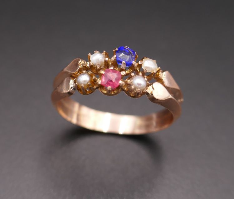 Antiker Ring mit Pferdekopf-Stempel, roten und blauen Steinen und Perlen.