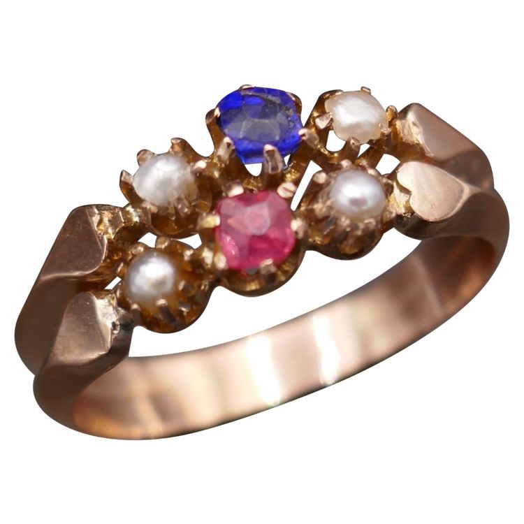 Antiker Ring mit Pferdekopf-Stempel, roten und blauen Steinen und Perlen.